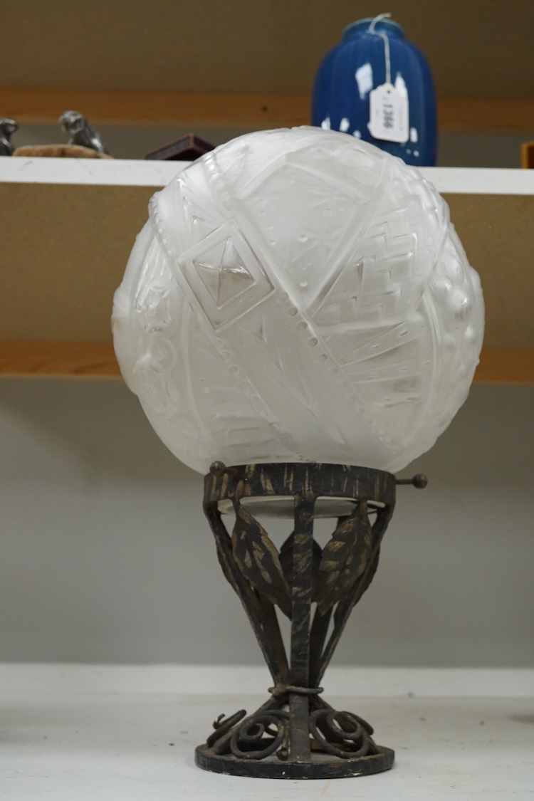 An Art Deco wrought and cast iron ceiling light with pressed glass shade, 44cm high